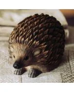 DecoAnimal Igel von Wildlife Garden auf einer hellen Stoffunterlage, mit dunkelbraunen geschnitzten Stacheln, schwarzen Augen, spitzer Schnauze und kleinen Pfoten.
