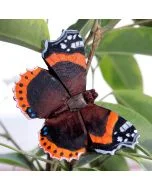 DecoButterfly Admiral von Wildlife Garden als Holzschmetterling zwischen grünen Blättern, mit dunkelbraunen Flügeln, orangefarbenen Binden und weißen Flecken.