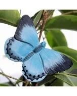 DecoButterfly Faulbaum-Bläuling von Wildlife Garden als blauer Holzschmetterling zwischen grünen Blättern, mit schwarzen Flügelspitzen und dunklen Punkten.