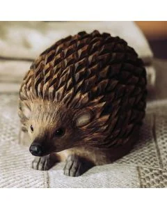 DecoAnimal Igel von Wildlife Garden auf einer hellen Stoffunterlage, mit dunkelbraunen geschnitzten Stacheln, schwarzen Augen, spitzer Schnauze und kleinen Pfoten.