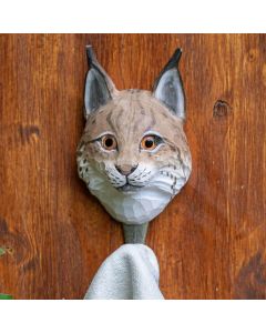 Kleiderhaken Luchs von Wildlife Garden an einer Holzwand, mit braun-weißem Luchskopf und einem hellen Handtuch am Metallhaken.