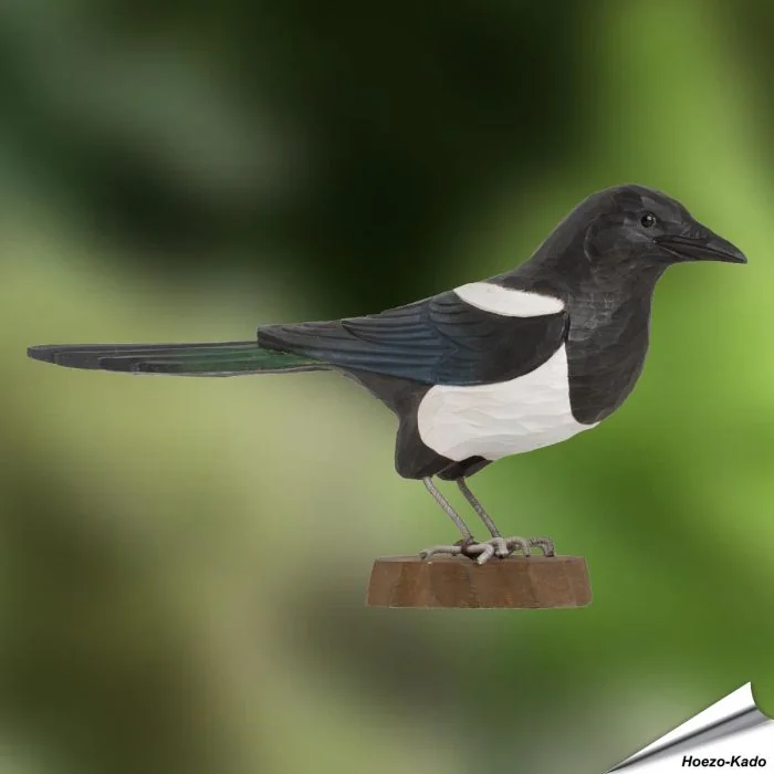 Handgeschnitzte Elster aus Holz mit markanter schwarz-weißer Farbverteilung und langer Schwanzpartie. Geschenkidee für Vogel- und Naturfreunde.