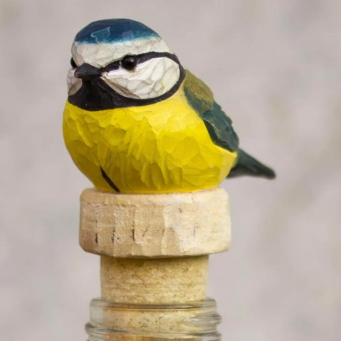 Flaschenverschluss Blaumeise von Wildlife Garden auf einer Glasflasche, mit handgeschnitztem Holzkopf, blauer Haube, gelbem Bauch und Naturkorken.
