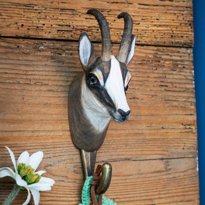 Kleiderhaken Gämse von Wildlife Garden an einer rustikalen Holzwand, mit braun-weißem Gämsenkopf, gebogenen Hörnern und Metallhaken.