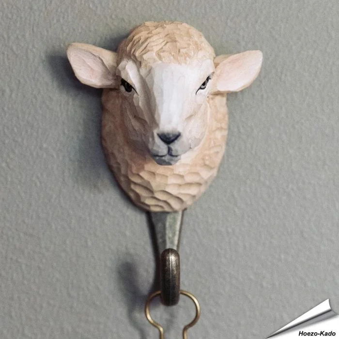 Handgeschnitzter Kleiderhaken Hausschaf von Wildlife Garden aus Holz, mit Glasaugen und bronzefarbenem Metallhaken. Dekorativ und praktisch.