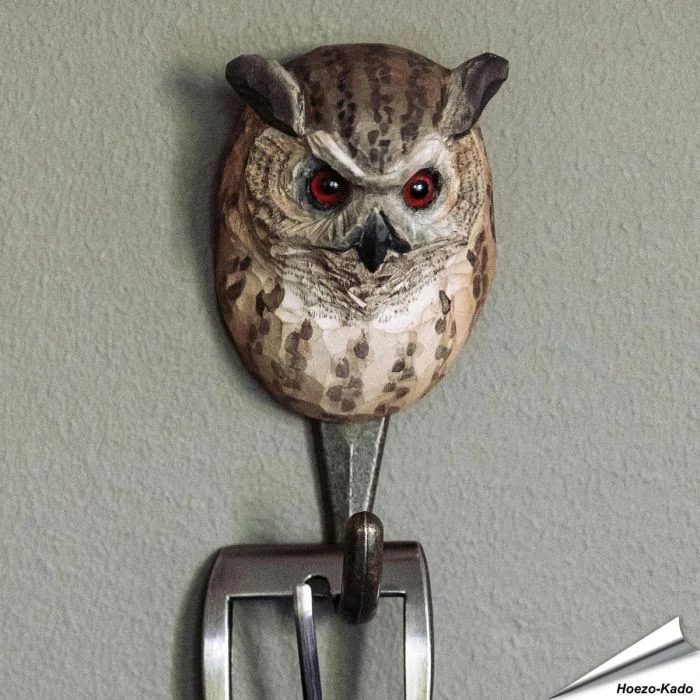 Handgeschnitzter Kleiderhaken Uhu von Wildlife Garden mit Holzkopf, Metallhaken, Federohren und orangefarbenen Augen. Ca. 5,9 x 4,7 x 12 cm.