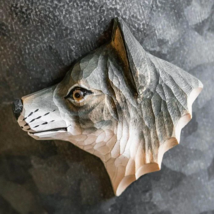 Kühlschrankmagnet Grauer Wolf aus Holz von Wildlife Garden mit graubraunem Fell, spitzem Ohr und heller Schnauze auf einer dunkelgrauen Metallfläche.